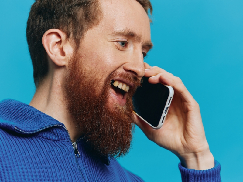 JSBL Group Contact Image A man with a beard holding a phone to his ear and speaking